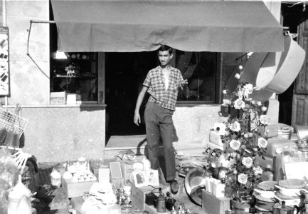 20 agosto 1967, il negozio di adamo francesco espone sul marciapiede la sua merce in vendita per la festa della madonna della catena. Nella foto, il figlio Pippo.